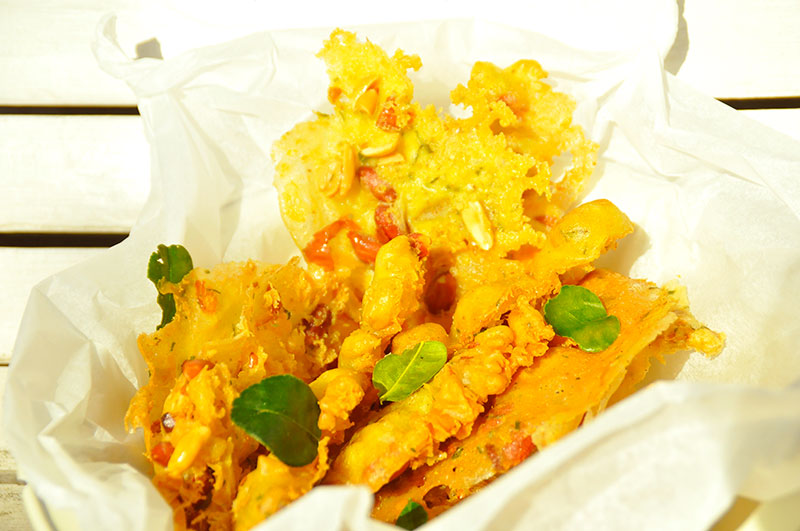 Rempeyek in schaal met wit bakpapier en djeroek poeroet